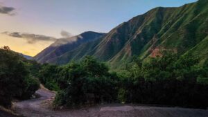 The first golden rays of sunlight break through the mountains near Ami’s Campground, illuminating the rugged peaks.